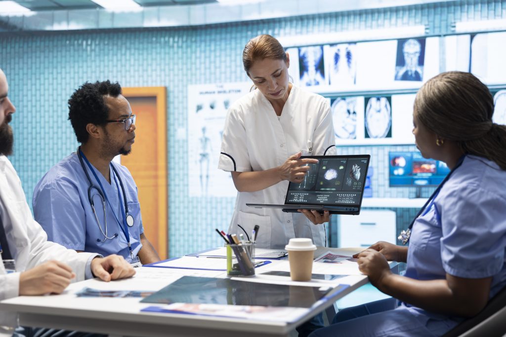 Team of specialists reviewing ecg results in a meeting at a private clinic, analyzing cardiovascular system on a radiography for disease prevention. Consulting cardiac scans and records.